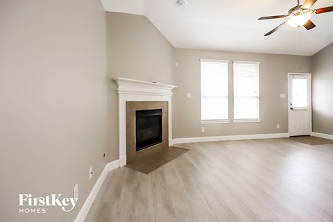 a living room with a fireplace and a ceiling fan