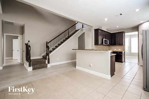 the kitchen and living room are open to the staircase to the second floor