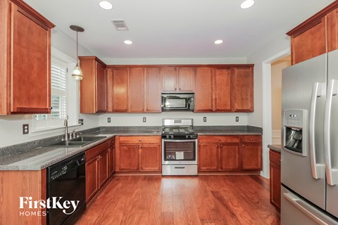 A kitchen with wooden cabinets and a stainless steel refrigerator.