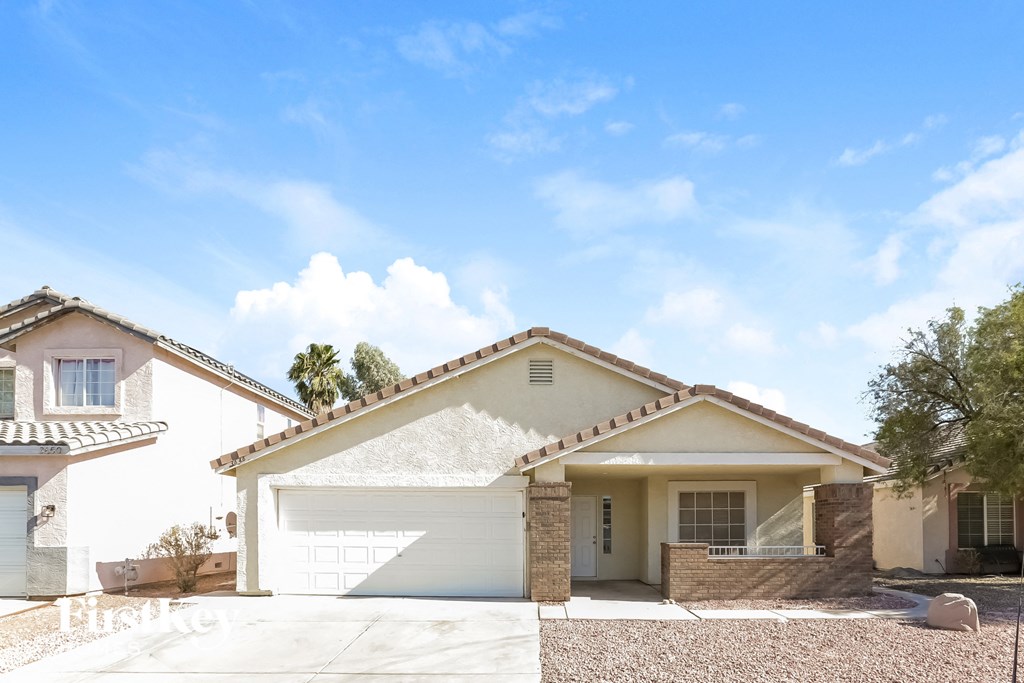a white house with a garage door and a driveway