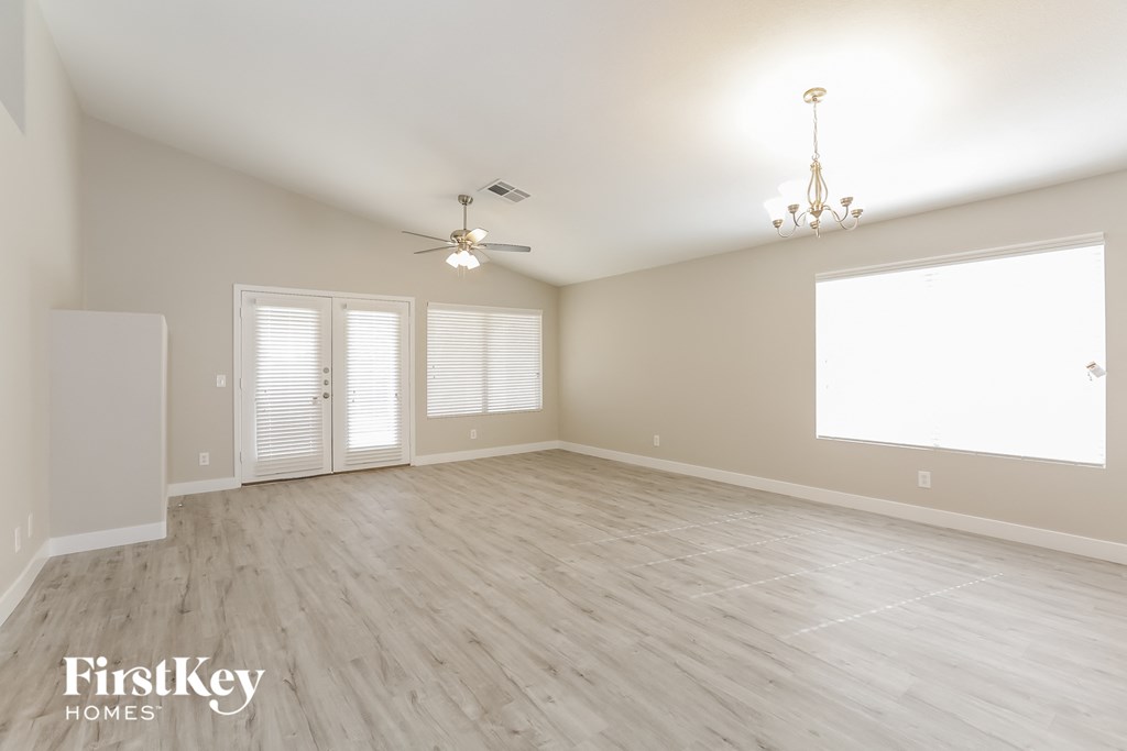 the spacious living room with hardwood floors and a large window