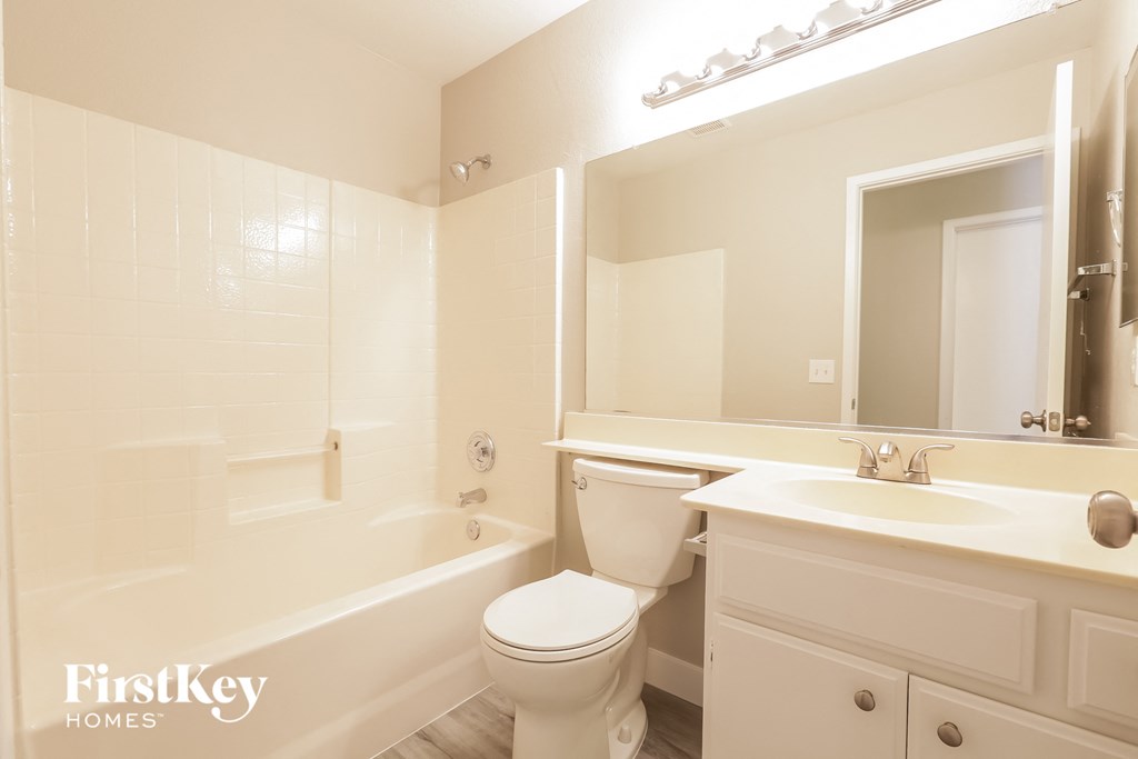 a bathroom with a toilet sink and tub and a mirror