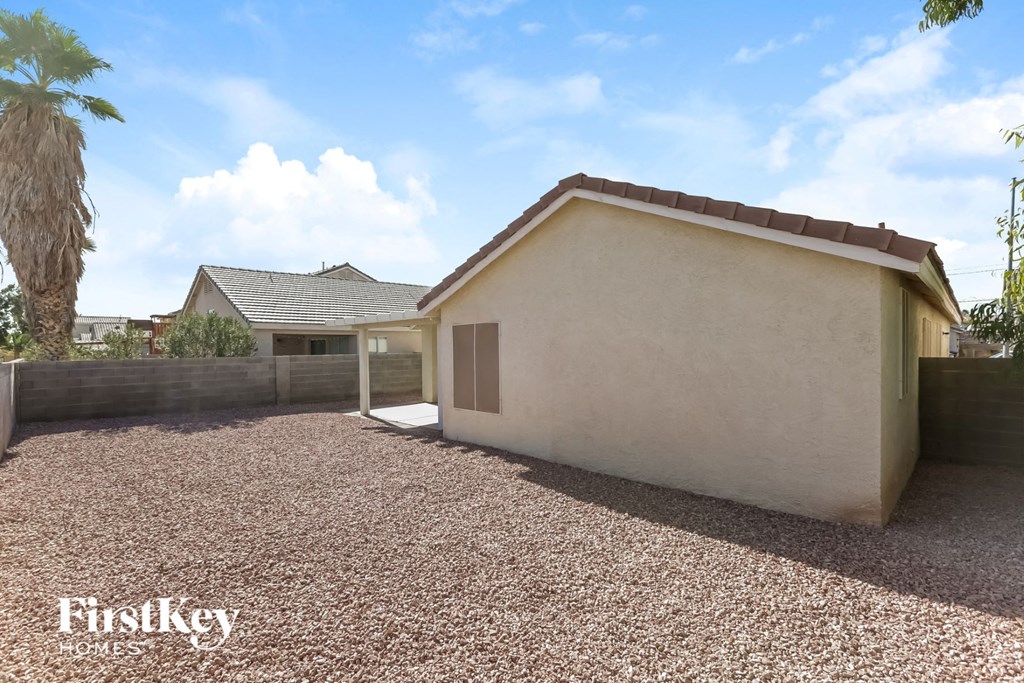 a side view of a house with gravel and a driveway