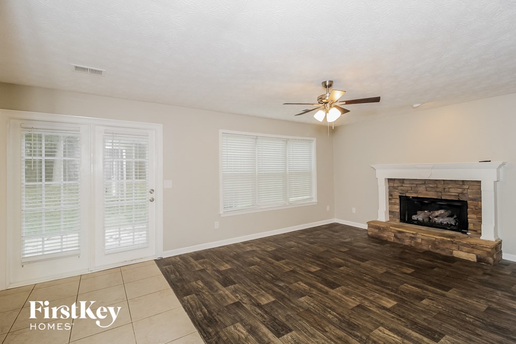 a living room with a fireplace and a ceiling fan