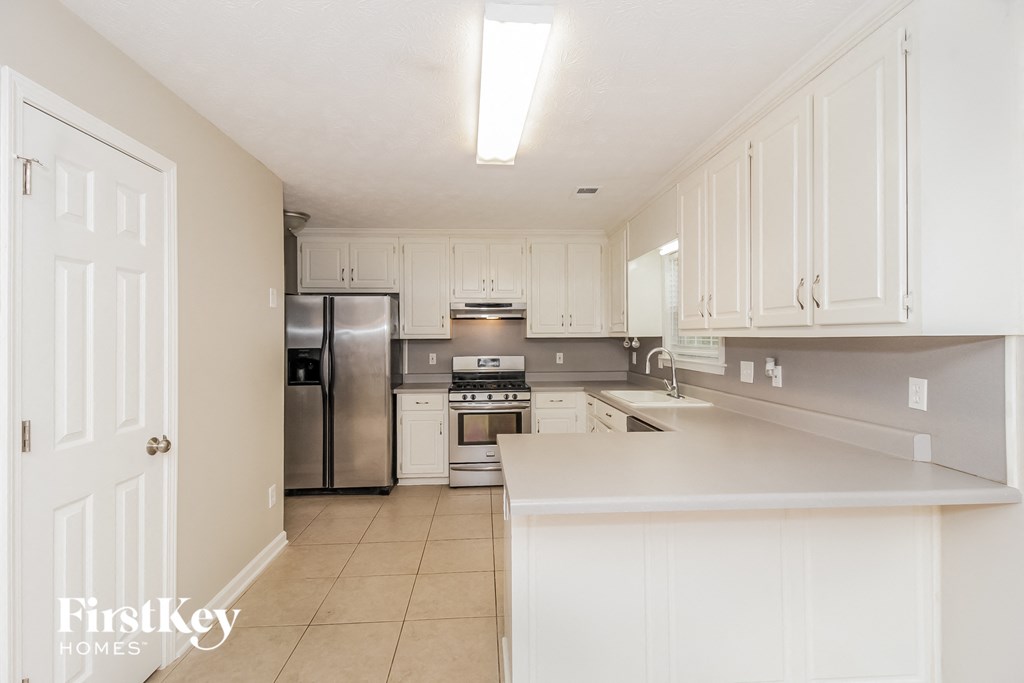a white kitchen with stainless steel appliances and white cabinets