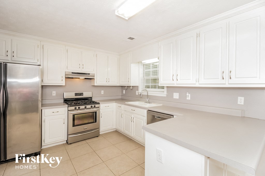 a white kitchen with stainless steel appliances and white cabinets