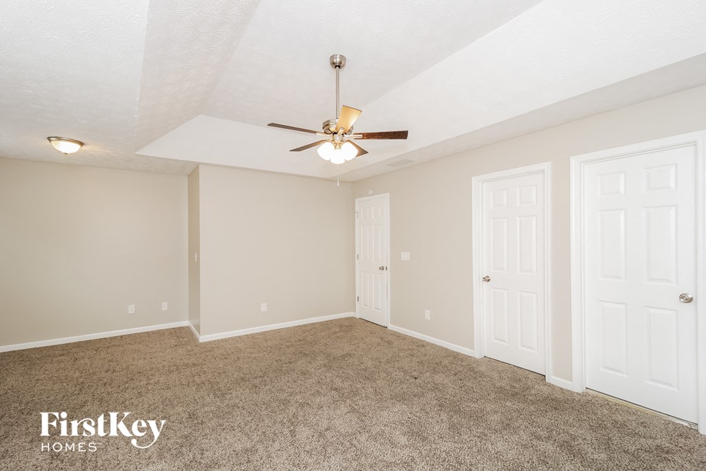 a bedroom with two closets and a ceiling fan