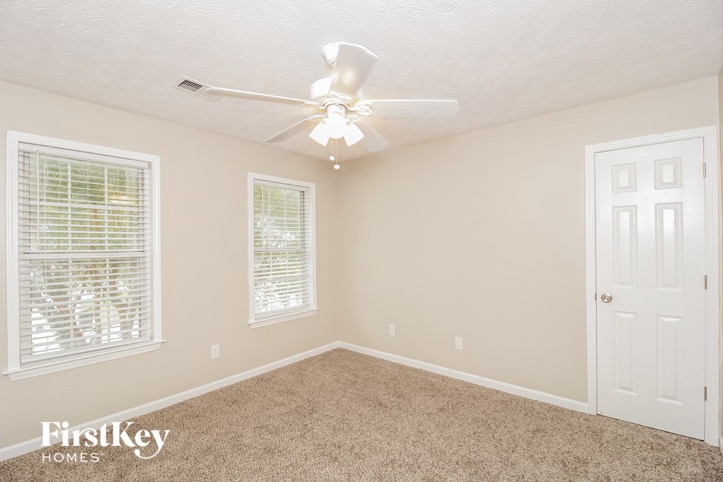 a bedroom with a ceiling fan and a white door