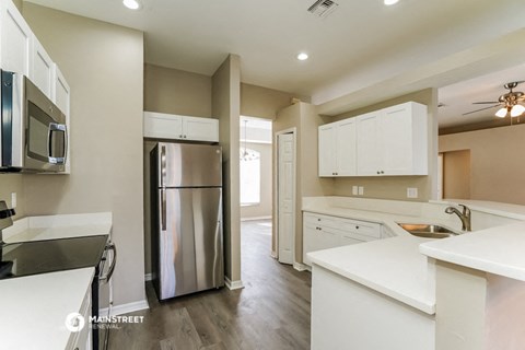 a kitchen with white cabinets and a stainless steel refrigerator