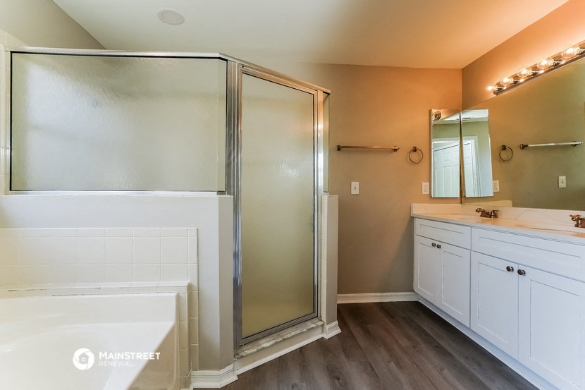 a bathroom with a shower and a sink and a mirror