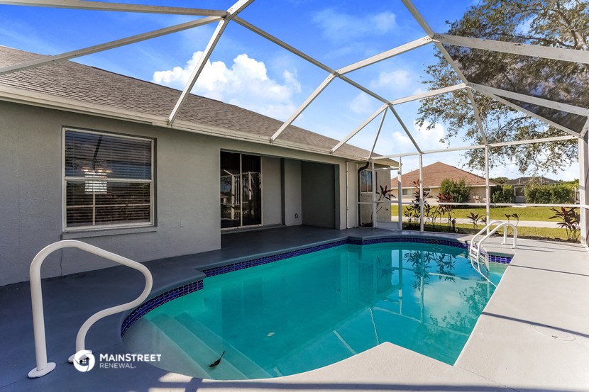 a swimming pool in front of a house with a pool