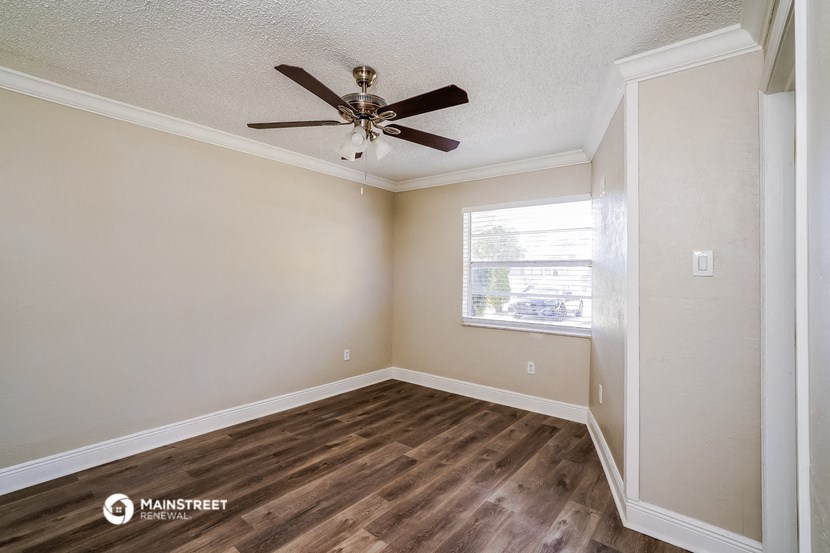 an empty room with a ceiling fan and a window