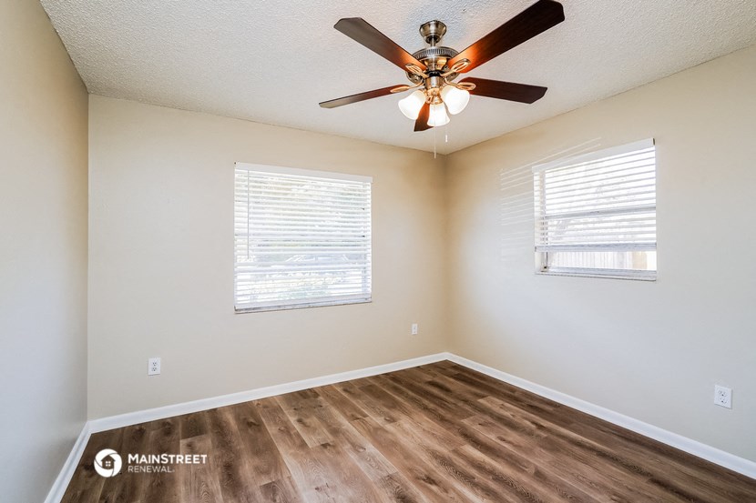 the spacious bedroom has a ceiling fan and a window