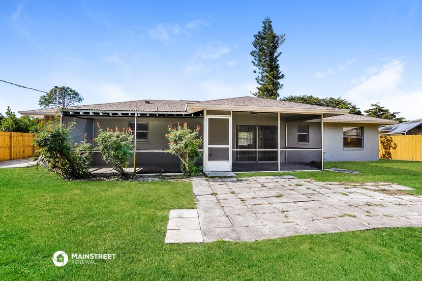 the front of a house with a lawn and a stone walkway
