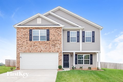 a brand new house with a brick facade and a white garage door