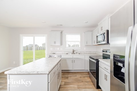 a white kitchen with stainless steel appliances and white counter tops