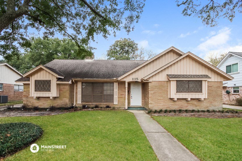 the front of a house with a lawn and a sidewalk