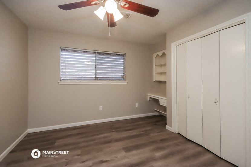 a bedroom with a closet and a ceiling fan