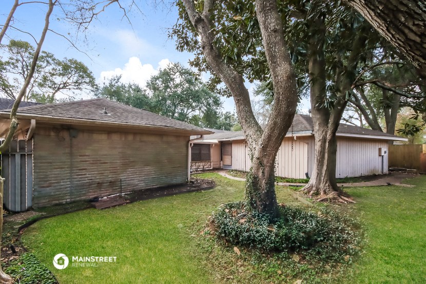 a backyard with a house and a tree
