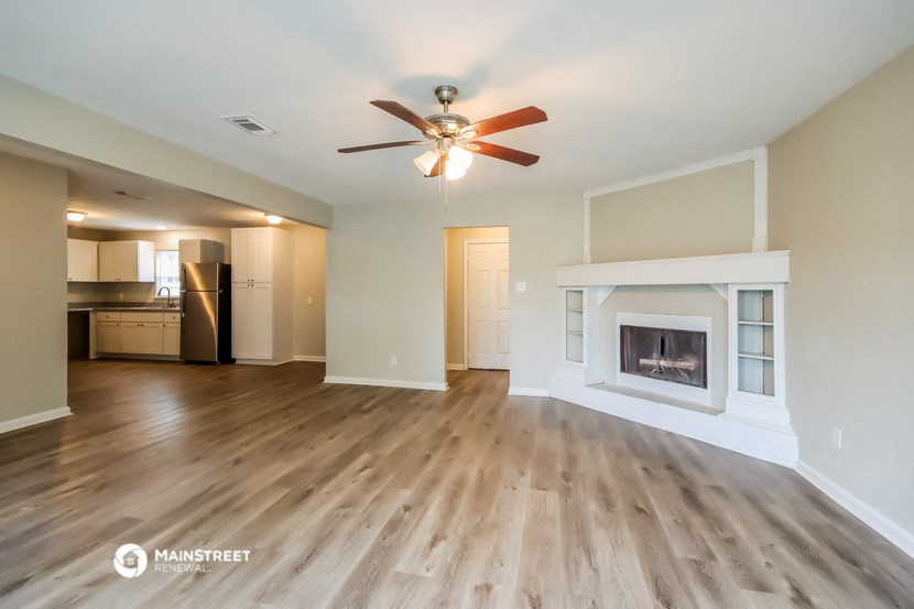 a living room with a fireplace and a ceiling fan