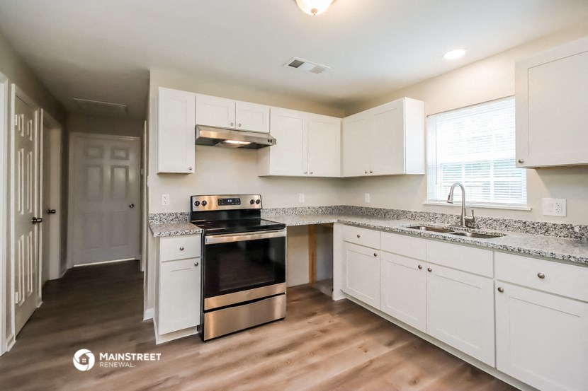 a kitchen with white cabinets and stainless steel appliances