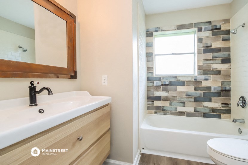 a bathroom with a sink and a bath tub and a mirror