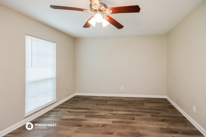 a bedroom with a ceiling fan and a window