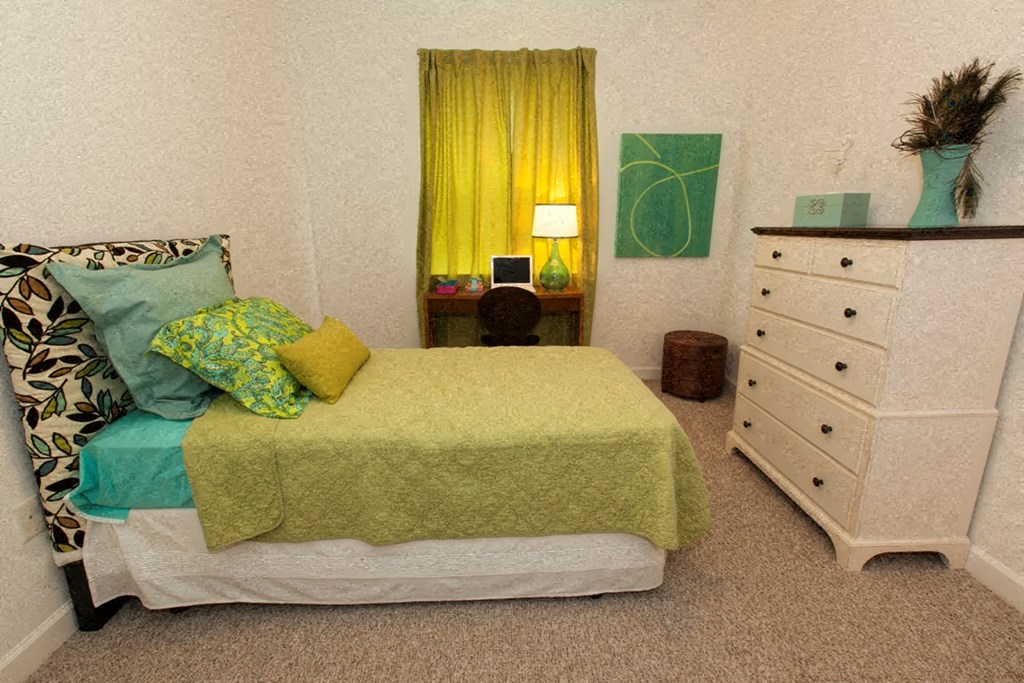 a small bedroom with a bed and a dresser