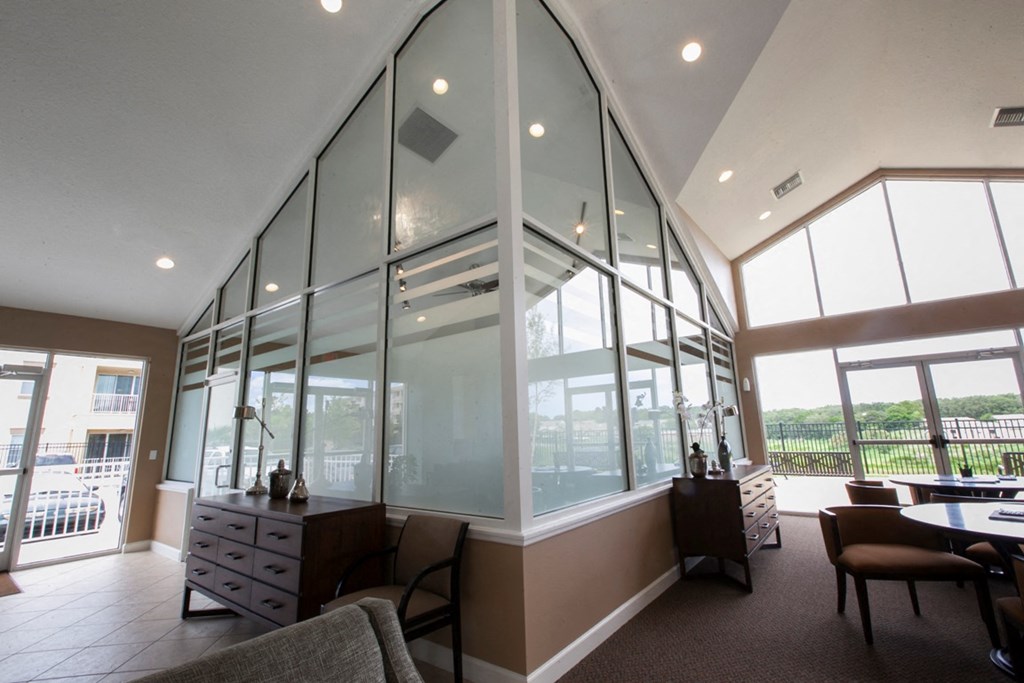 a dining room with large windows and a table and chairs