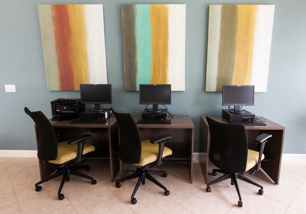two desks with computers and chairs in a room