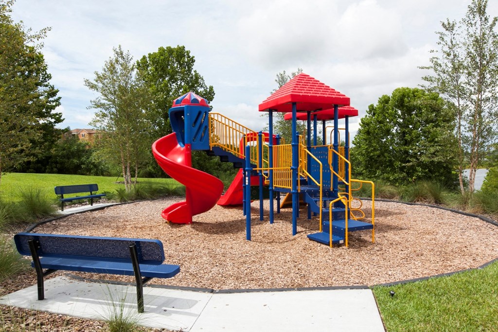 a playground with a swing set and a slide in a park