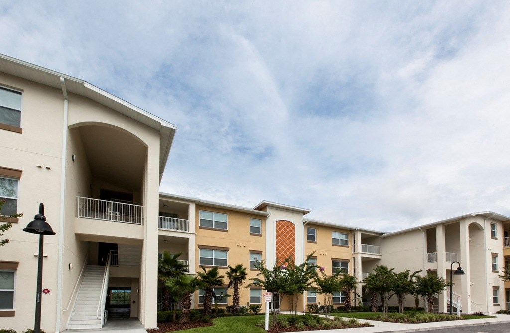 a row of apartments with stairs and palm trees