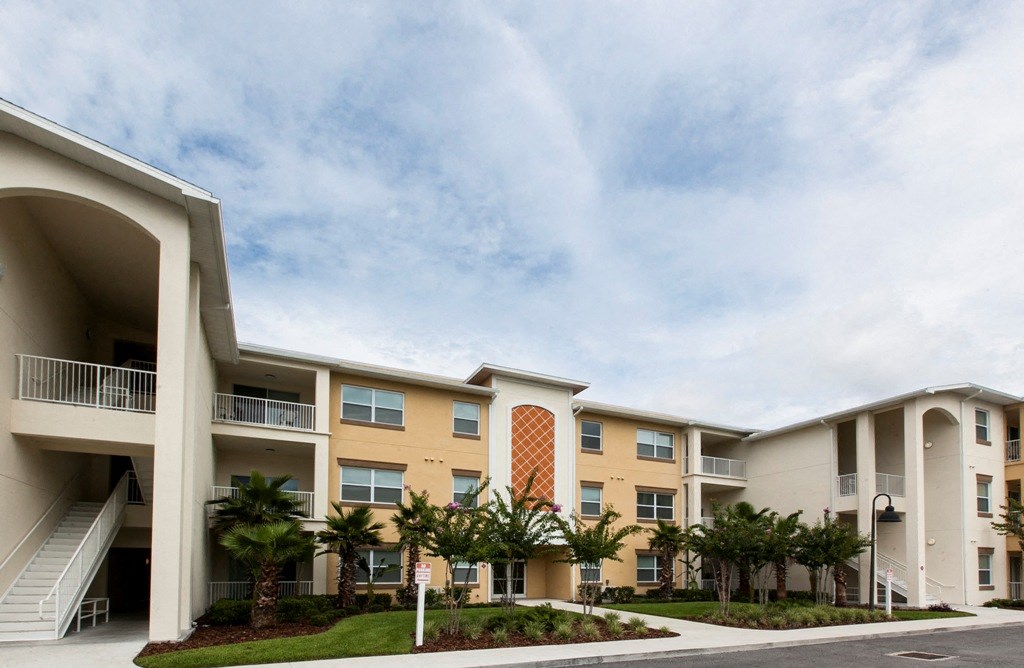 an apartment building with palm trees in front of it