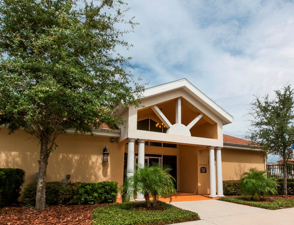 a house with a sidewalk and a tree in front of it