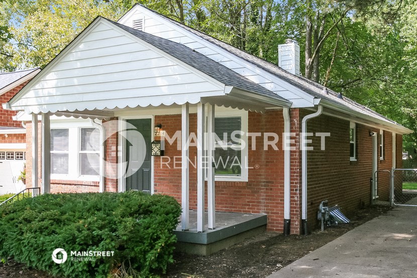 a small brick house with a covered porch