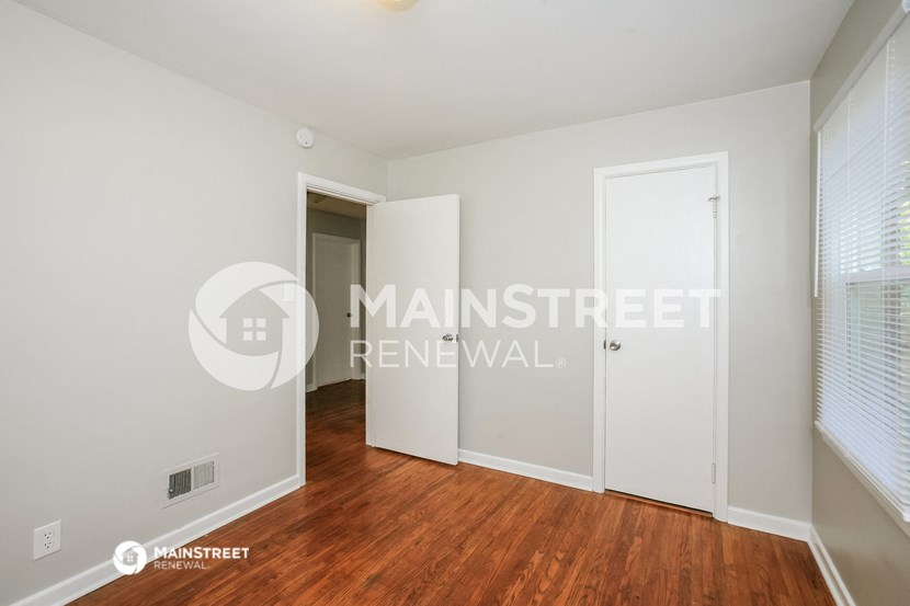 a bedroom with a closet and a door to a hallway