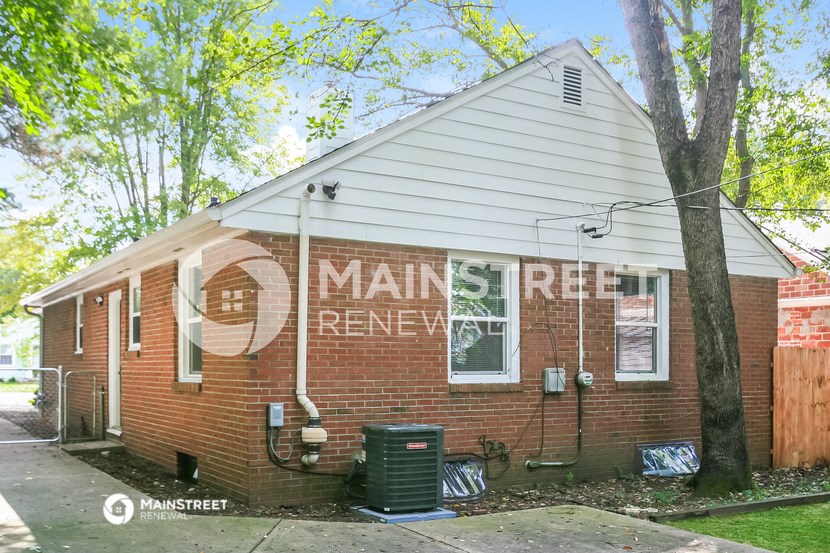 an old red brick house with a sign on the side of it