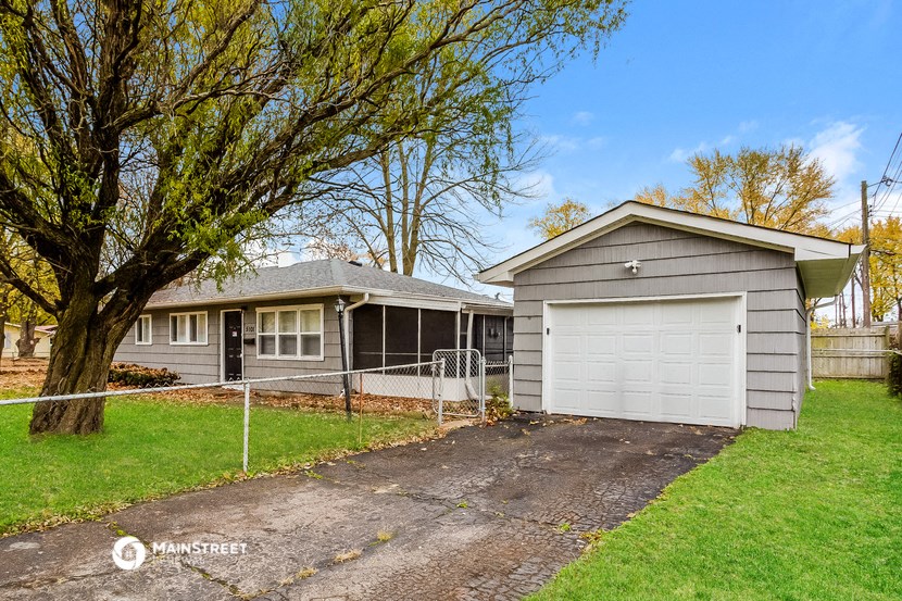 a gray house with a driveway and a white garage door