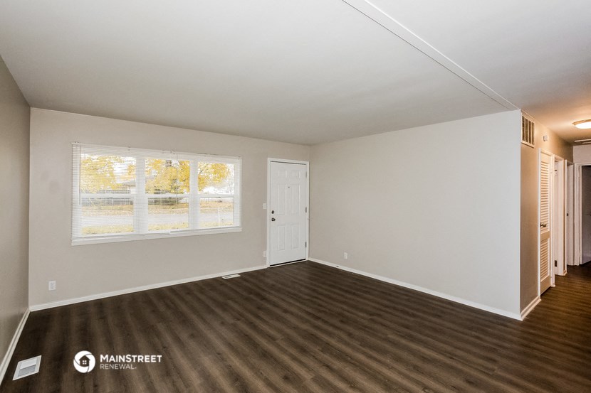 the living room of an empty house with a large window
