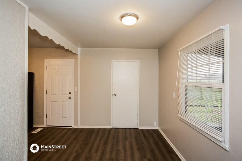 the interior of an empty room with a white door and a window