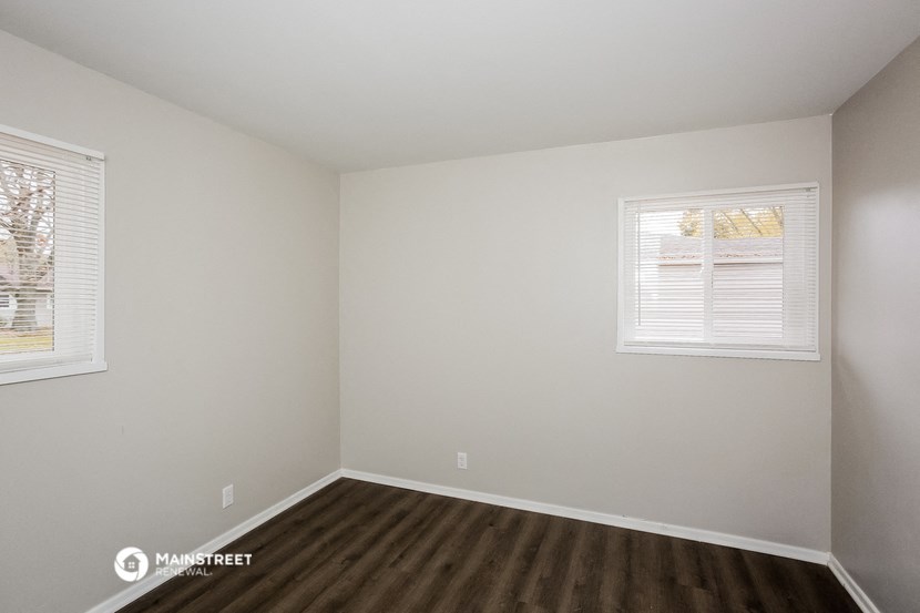 the interior of a small room with wooden floors and a window
