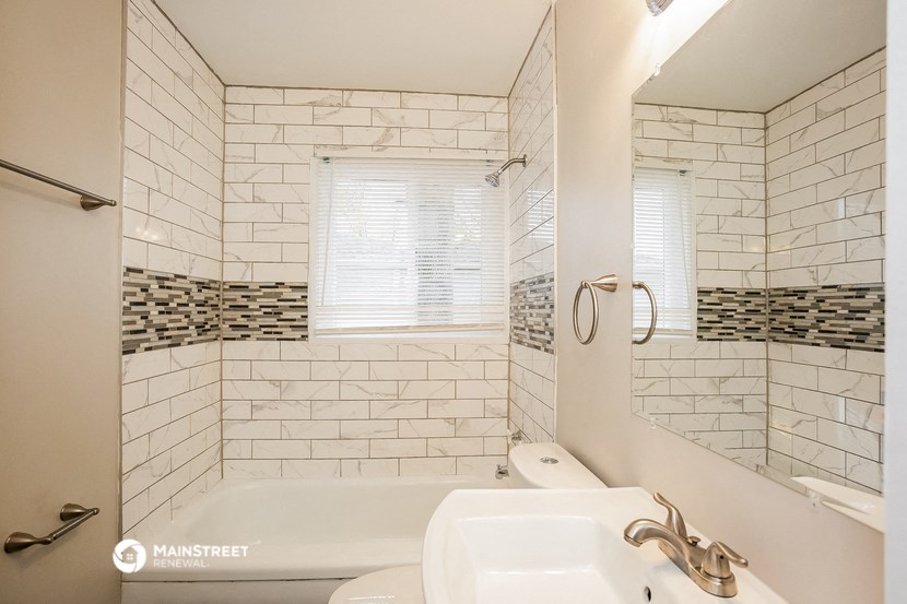 a bathroom with a tub and a sink and a mirror