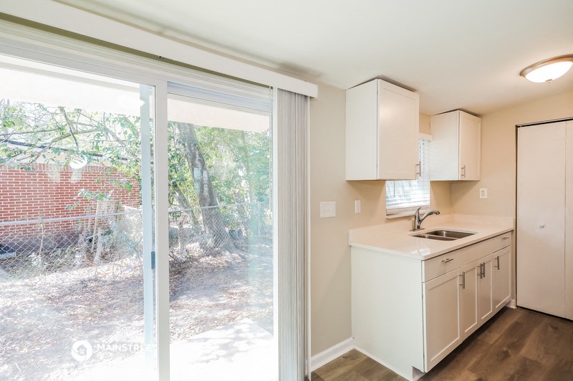 a kitchen with a sliding glass door leading to a backyard