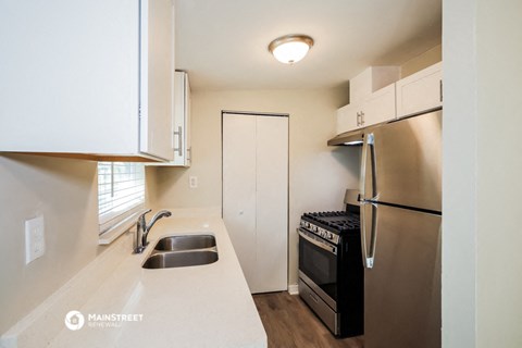 a kitchen with a sink and a refrigerator and a stove