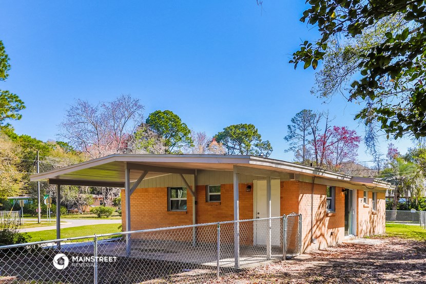 a small brick building with a fence in front of it