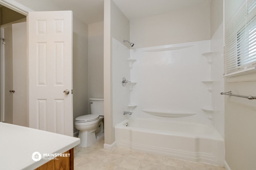 a bathroom with a tub and a toilet and a sink