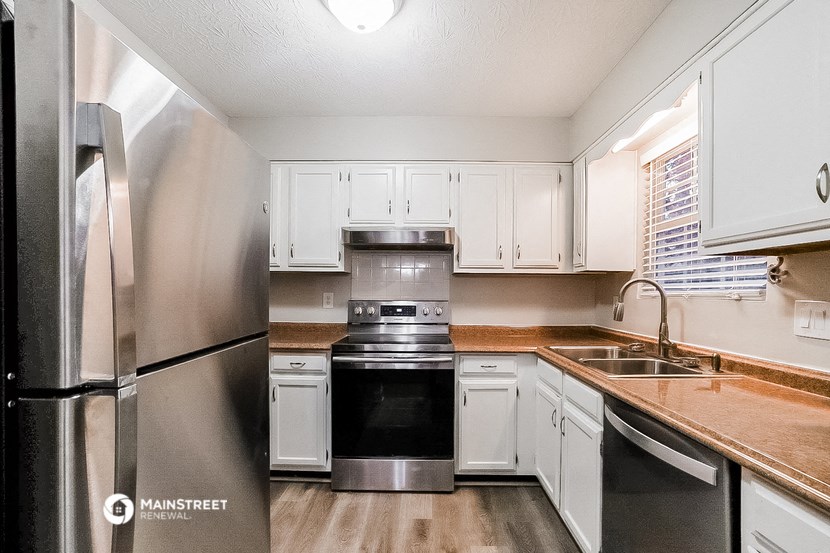 a kitchen with white cabinets and stainless steel appliances