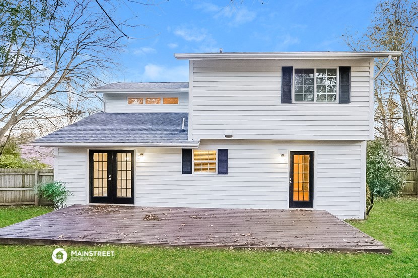 a white house with a porch and a blue roof