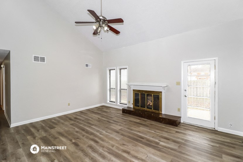 a living room with a fireplace and a ceiling fan