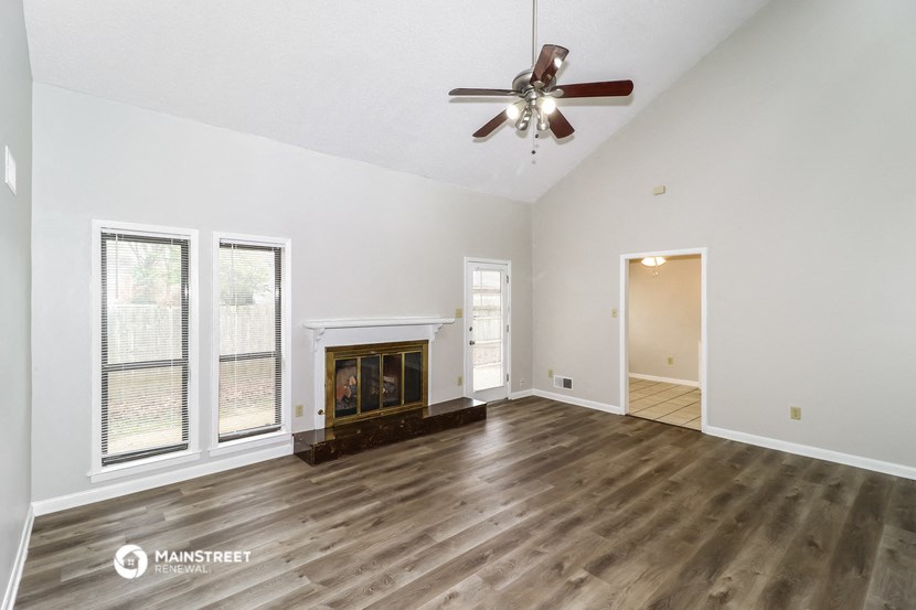 a living room with a fireplace and a ceiling fan